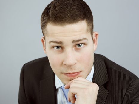 Portrait of self-confident young man in business clothes looking straight into camera