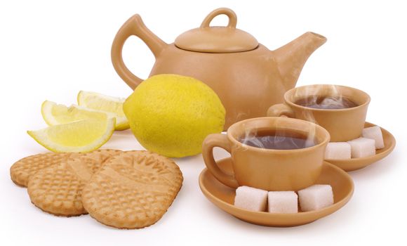 set of the earthenware teapot, two cups of tea, lump shugar, sliced lemon and biscuits isolated on white background with clipping path                   