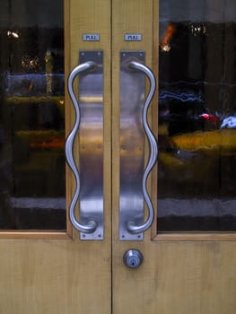 Silver door handles on a wood and glass door