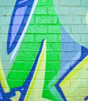 Bright glossy green design painted on a on brick wall