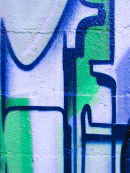 Bright green, white and blue design painted on a brick wall