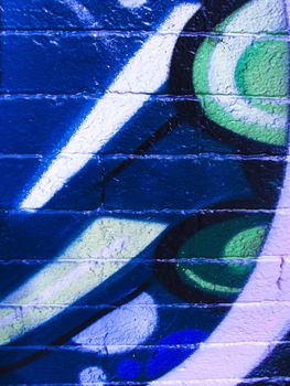 Multicolor shapes painted on blue concrete brick background