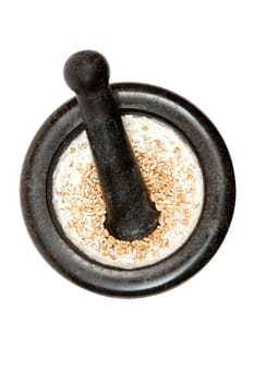 Grinding wheat in a kitchen pestle. Isolated on a white background.