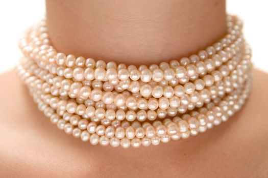 Precious pearls on a womans neck. White background.