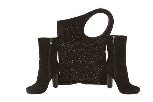 Pair of stylish female suede boots and a suede bag with costume jewellery isolated