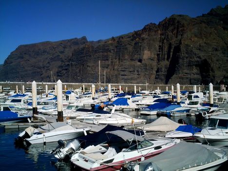Boats moored by Los Gigantes cliiffs on island of Tenerife, Spain.