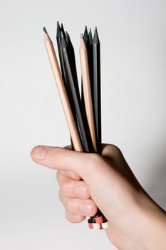 Pencils in a hand on a white background