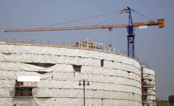 Overview of building site as construction taking place with crane.