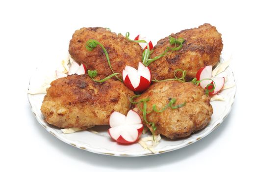 Meat rissoles with garden radish on a white round plate