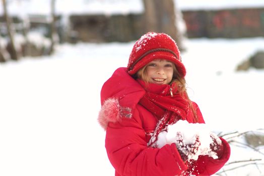 Happy young girl having fun outdoors in the cold and snow