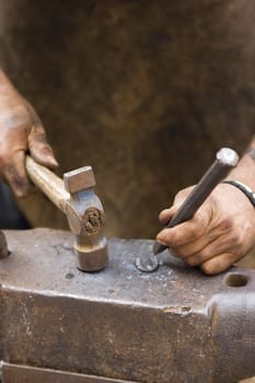 rude blacksmith striking the anvil with a hammer
