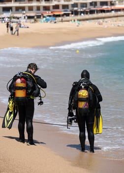 Two frogmens with aqualungs on a coast of the mediterranean sea. Spain