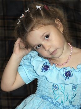 It is a photo of the little girl in a blue dress with curly long hair. It very beautiful.