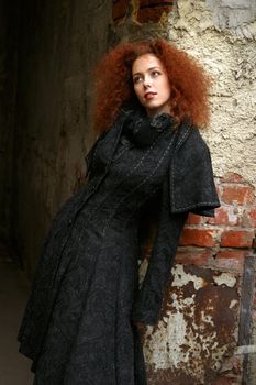 Portrait of the girl with red hair in a black coat