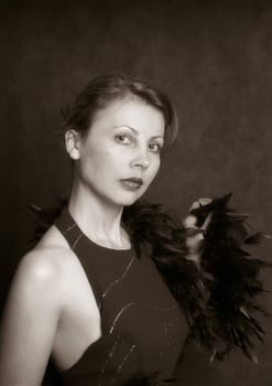 Portrait of the beautiful woman in an evening dress with feathers. b/w+sepia