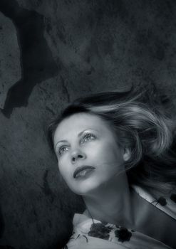 Portrait of the beautiful woman looking to the upwards. b/w+blue tone