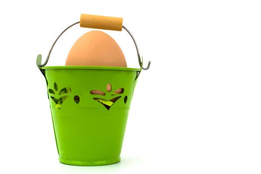 Uncolored egg in green basket, on white background.