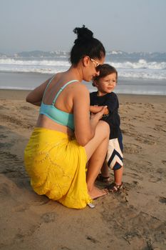 Mother and baby boy together on beach