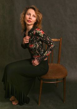 Portrait of the girl barefoot sitting on a chair