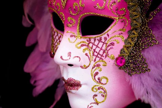 Violet-pink Venetian mask with decoration on black