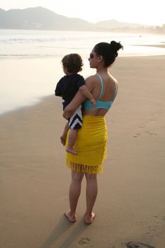 Mother and baby boy together on beach