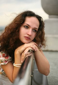Portrait of the thoughtful girl on a roof of a house