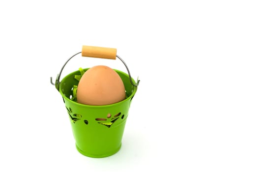 Uncolored egg in green basket, on white background.