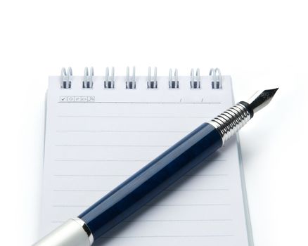 Pen on notebook, isolated on white background.