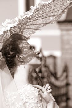The beautiful bride closed by a umbrella from the sun