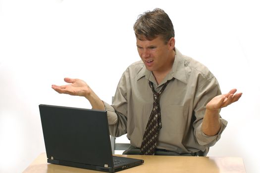 Businessman angry with his computer at the office.