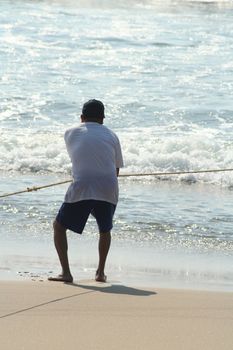 Fishermen pulling in net from the beach