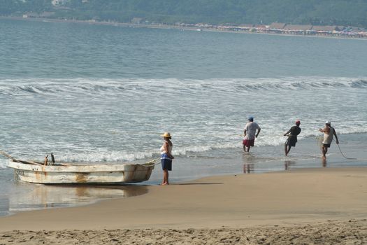 Fishermen pulling in net from the beach