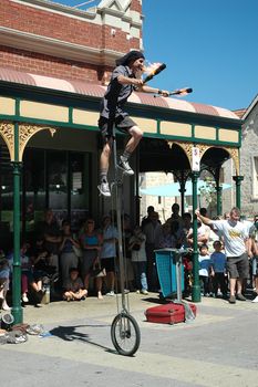 Street performer on one wheel juggling fire