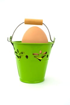 Uncolored egg in green basket, on white background.