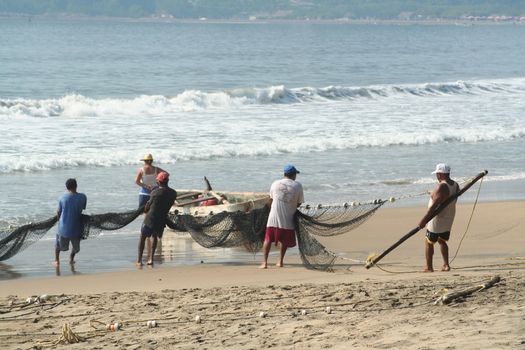 Fishermen pulling in net from the beach