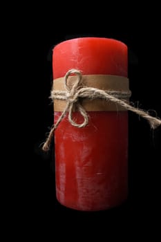 Close-up of a red candle on black background.