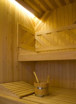 Bucket for water and two pillows on bench in Finnish sauna.