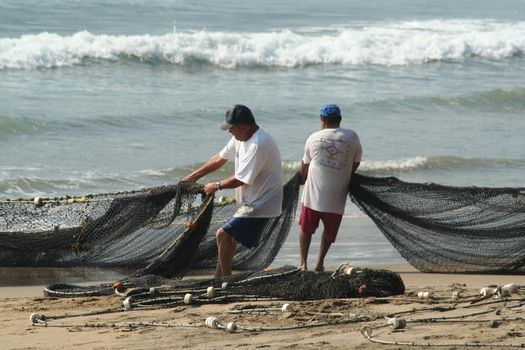 Fishermen pulling in net from the beach