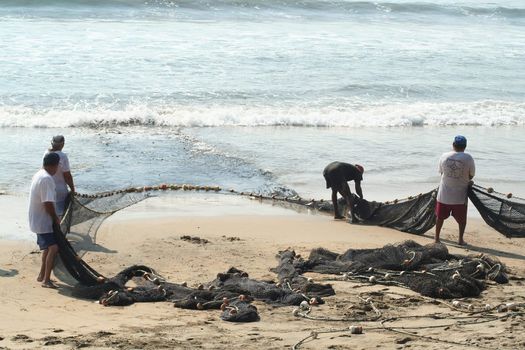 Fishermen pulling in net from the beach