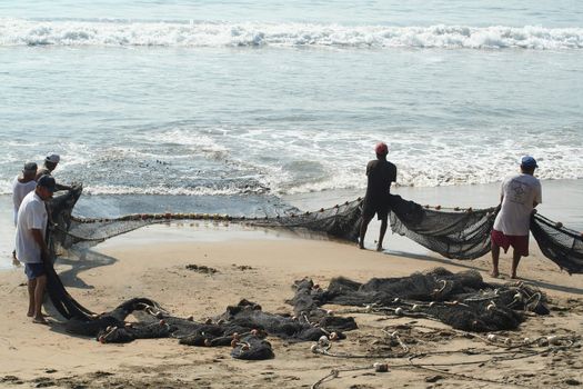 Fishermen pulling in net from the beach