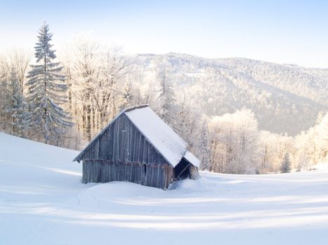 Abandoned wooden cottage in mountain under snow. Winter time.