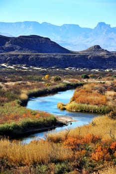 Image of winding stream in front of mountain range