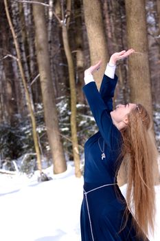 Lady in blue dress and tree trunks
