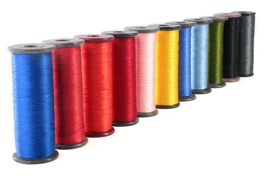 Colour threads for an embroidery on a fabric on a white background.