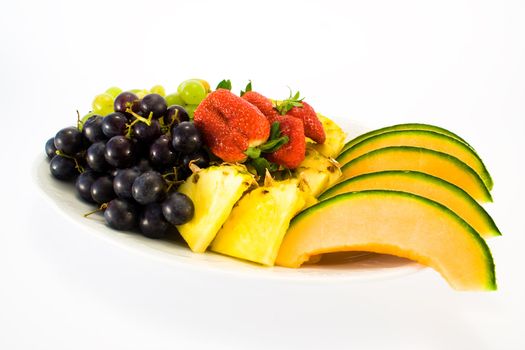 Plate full of fruit, isolated on white background.