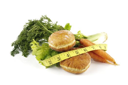 Contradiction between healthy food and junk food using a bunch of carrots and doughnuts with a tape measure on a reflective white background 