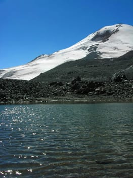 Mountain lake on a background of snow-covered top          