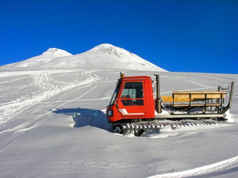 The red snowmobile  frozen in a snow.
          