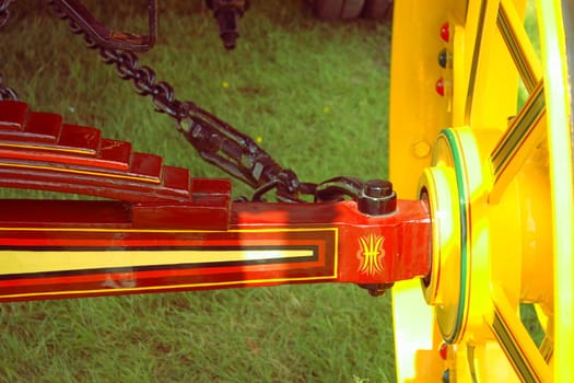 a close up shot of the axle and inside of a brightly painted fairground engine