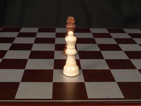 White king, black queen on a chess board